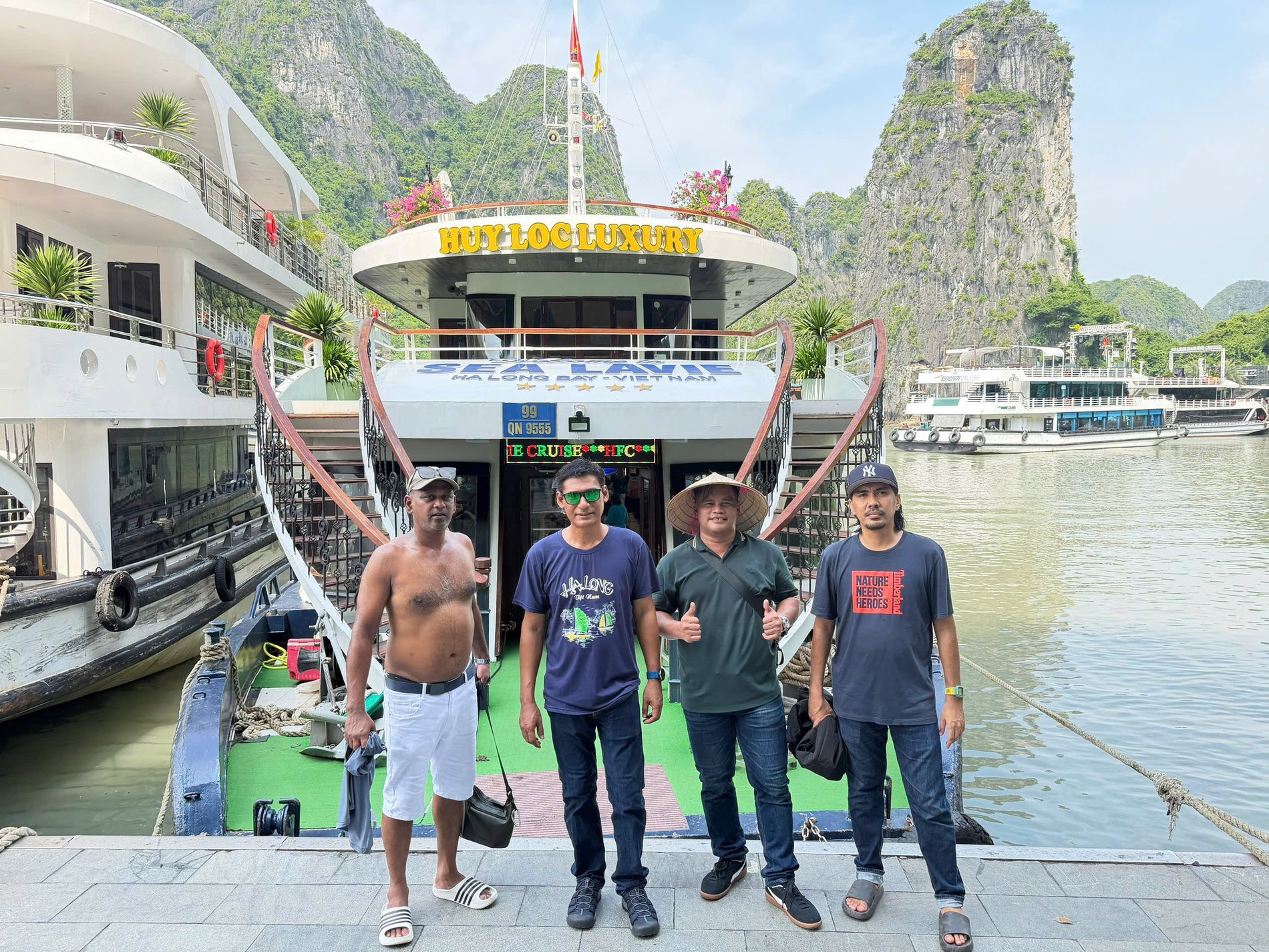 Travellers beside a cruise boat in Ha Long Bay